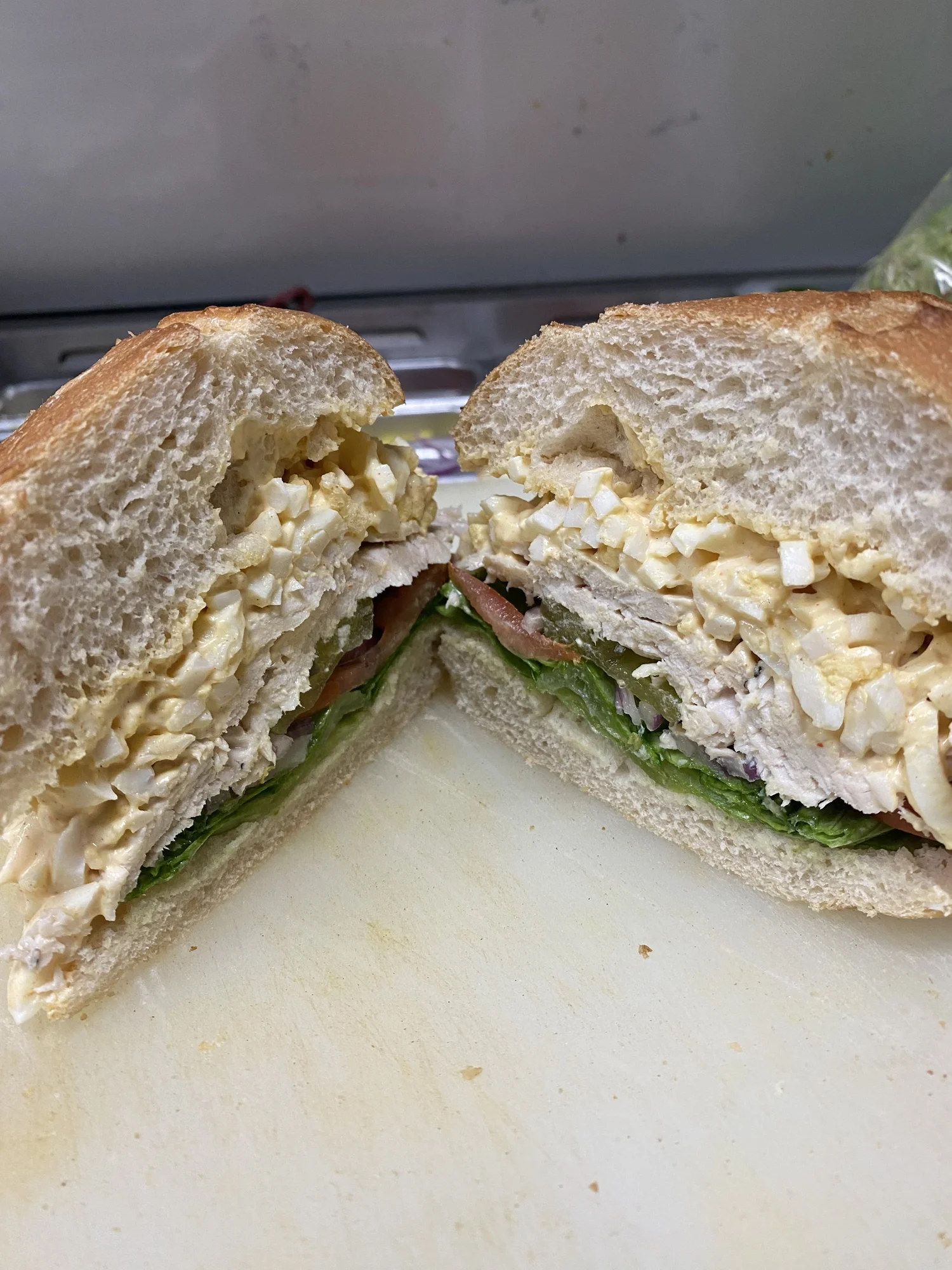 Egg salad and turkey sandwich, sliced in half, on sourdough
